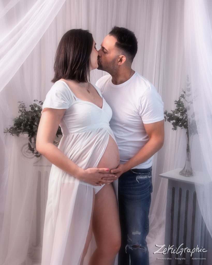 pareja embarazada posando en un decorado de estudio fotografico en Murcia